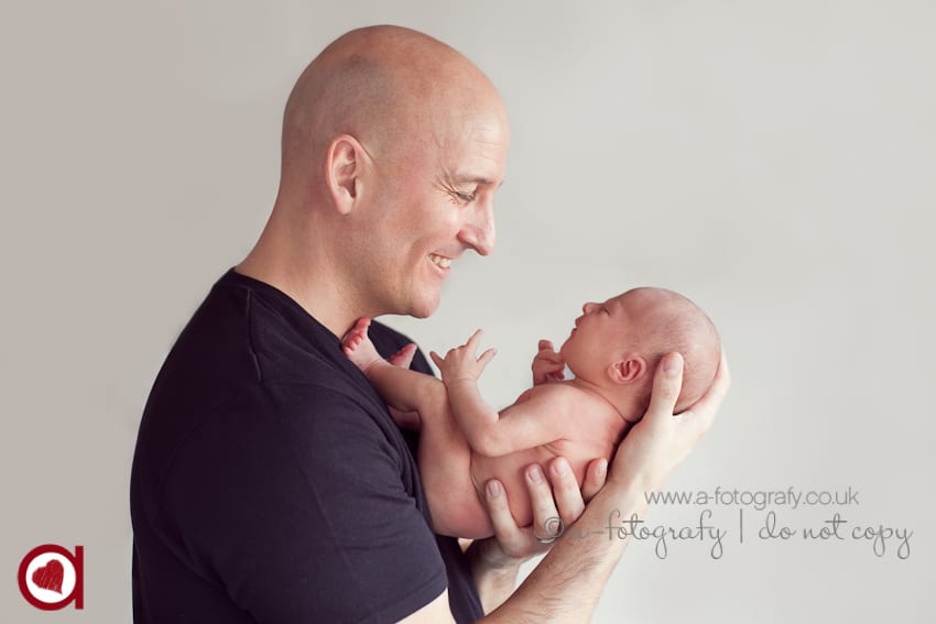dad is holding newborn baby girl in Falkirk