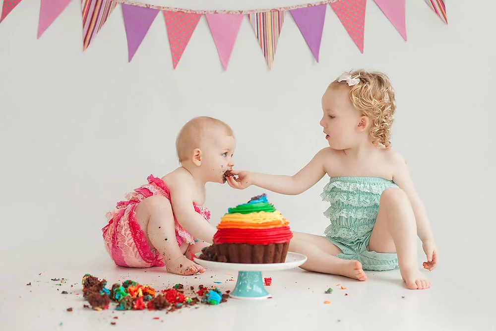 baby sisters sharing a cake during photoshoot in Edinburgh