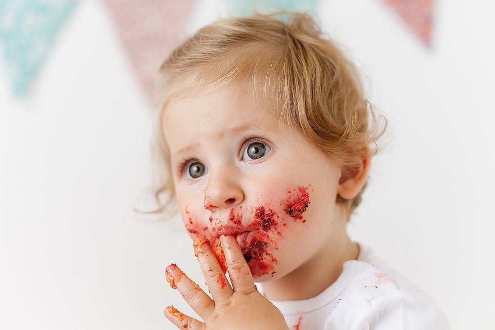 kid with red cake on the face during photoshoot in Edinburgh