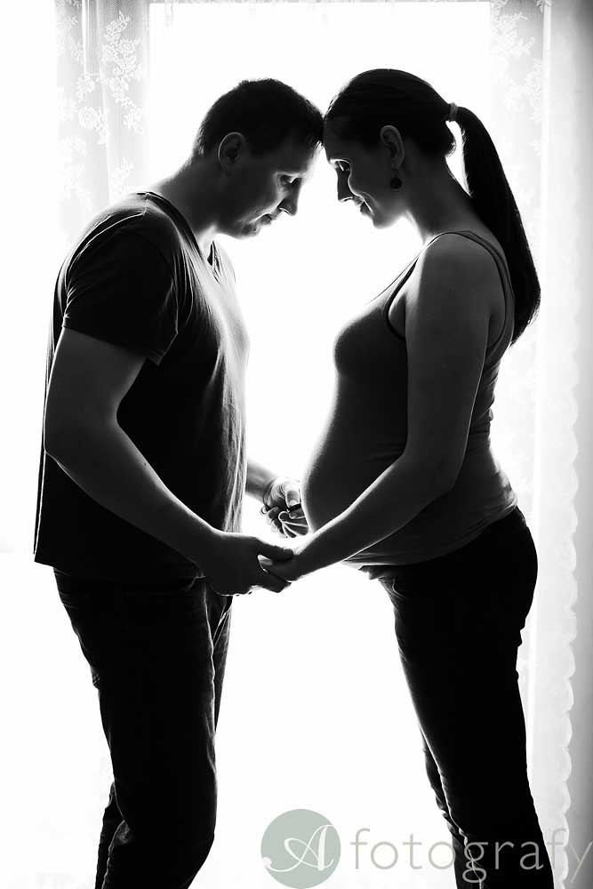 pregnancy home session with family against the window with silhouette effect