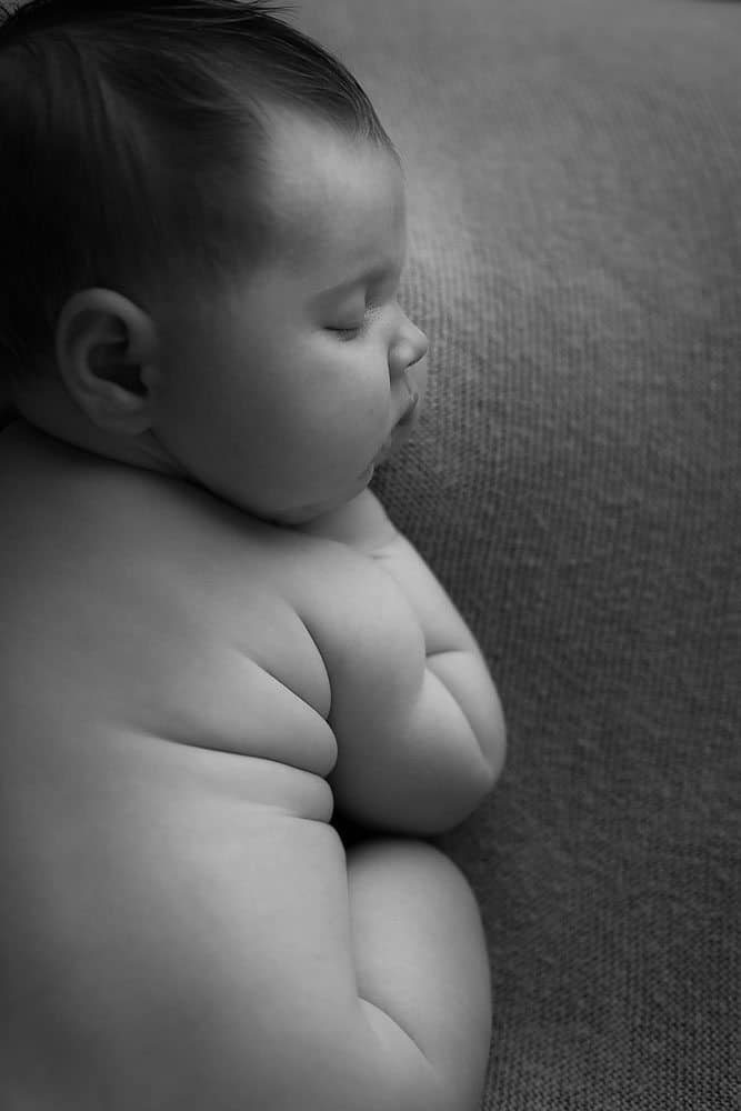 Black and white newborn portrait of baby fat rolls