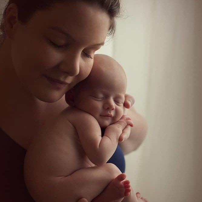 mommy is holding her newborn girl during photo shoot in Edinburgh studio