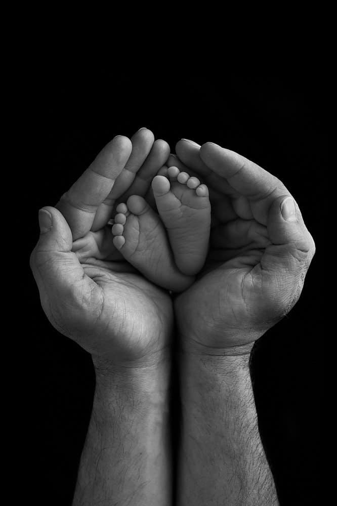 newborn photo of feet in dads hands