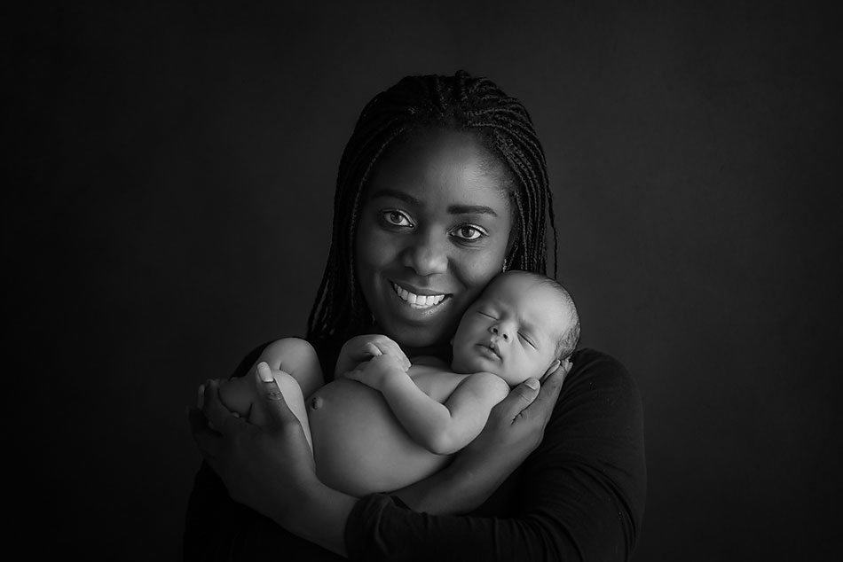 newborn baby held by his dark skin afro mommy