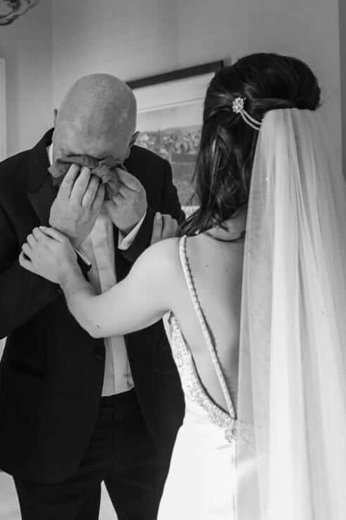 bride meets her dad after getting ready in the dres