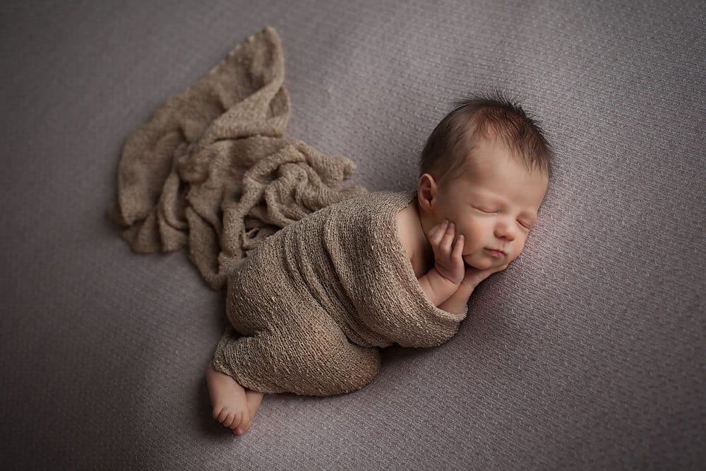 Newborn baby on side position during photoshoot in edinburgh