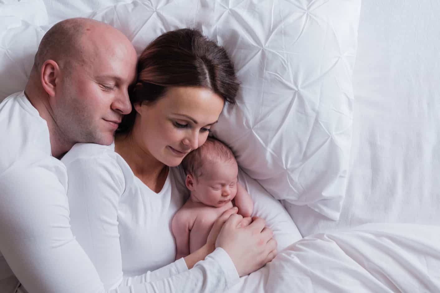 photographer takes newborn pictures at home with family