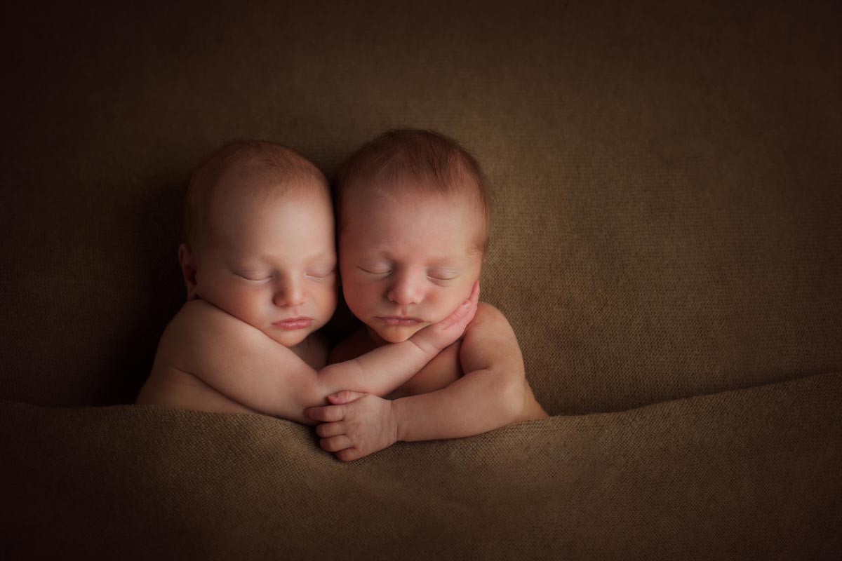 newborn twins hugging during photography photoshoot