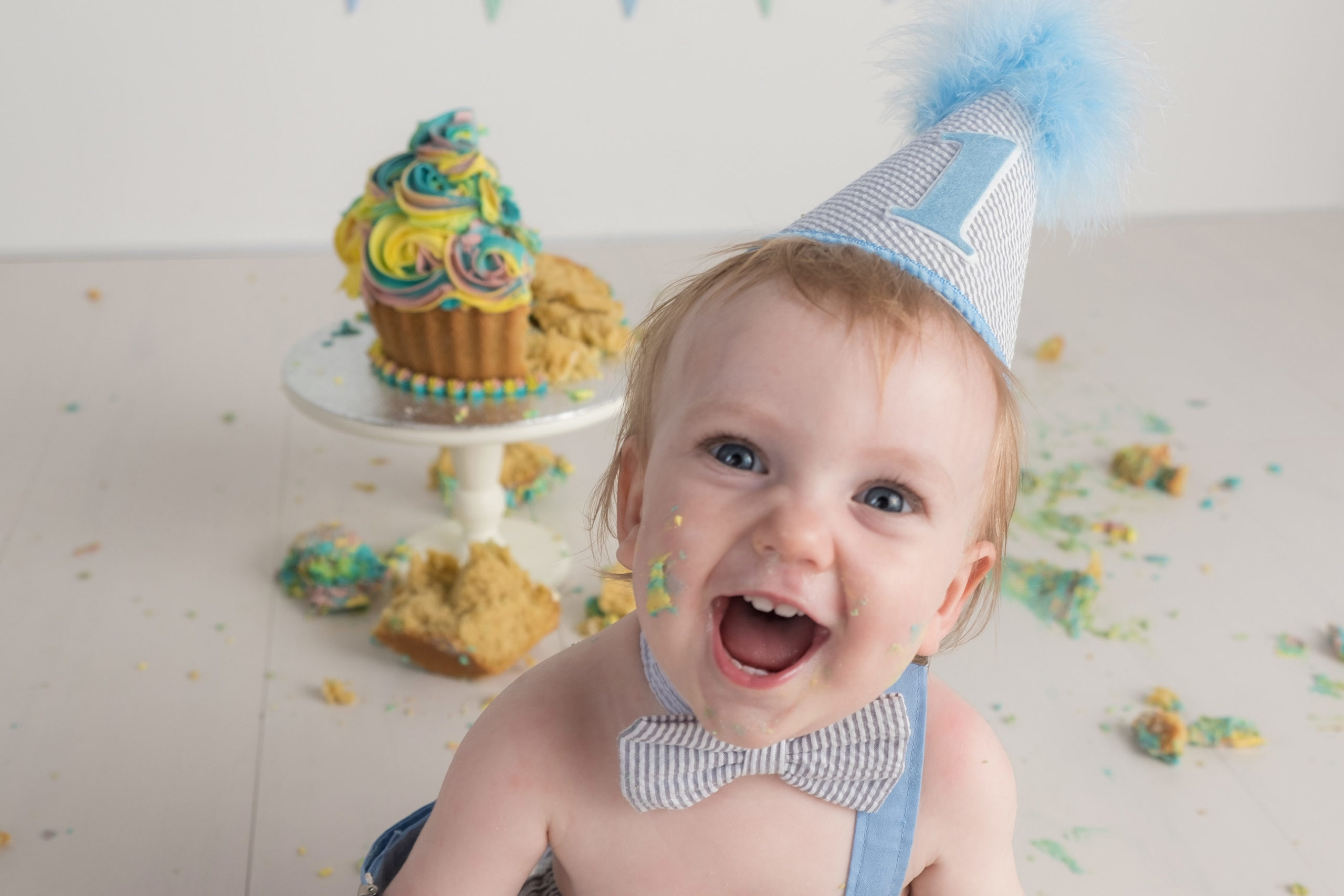 kid wearing blue hat during the cake smash photography session